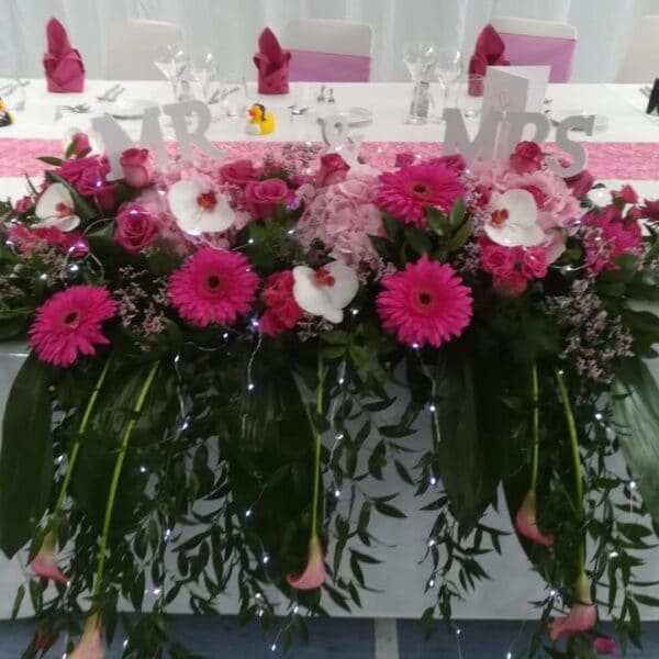 Arrangement de table d'honneur des mariés rose fuchsia