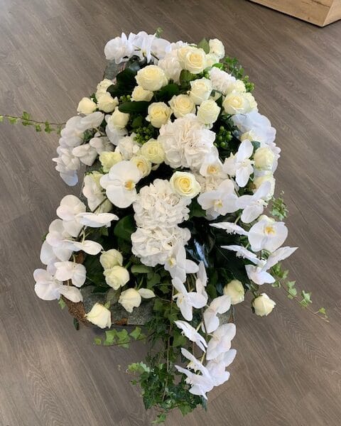 Dessus de cercueil tout blanc avec orchidées