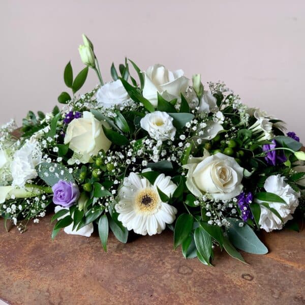 Arrangement de table ovale vert et blanc avec une touche de mauve