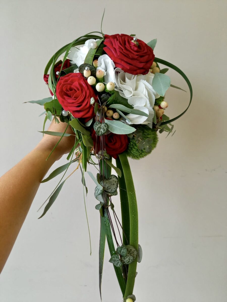 Bouquet de mariée rond rouge et blanc avec une retombée en feuillage