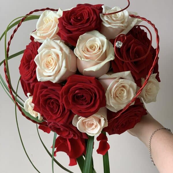 Alternative view of Bouquet de mariée rond rouge et crème avec une retombée en feuillage et pétales de roses stabilisées